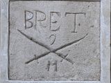 une plaque en pierre sur laquelle est représentée une paire de ciseaux