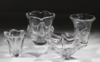 trois vases en verre posés sur une table, sur fond noir
