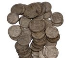 une pile de vieilles pièces d'argent sur une surface blanche