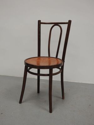 une chaise en bois avec un dossier et une assise courbés