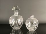 pair of clear glass perfume bottles sitting on top of a black table