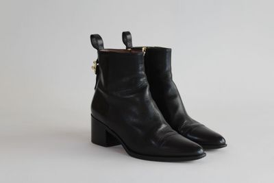 une paire de bottines en cuir noir sur fond blanc