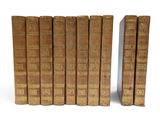 several old books are lined up in a row on a white surface