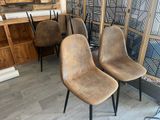 Plusieurs chaises sont alignées dans une pièce, avec un mur derrière elles.