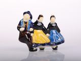 three figurines of people sitting on a bench