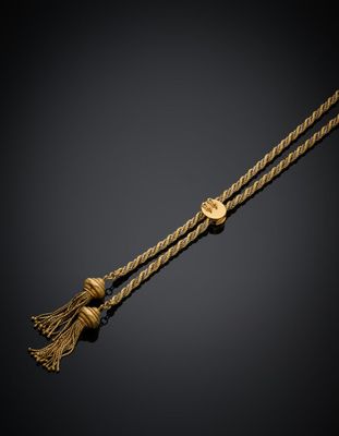 un collier en or orné d'un pompon sur fond noir