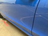 a blue car that is parked on the side of the street