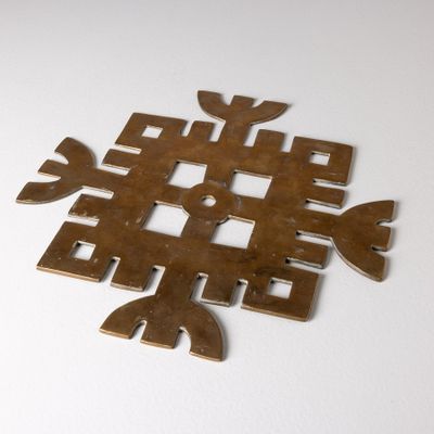 un flocon de neige en métal sur une surface blanche