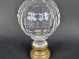un gros plan d'une boule en verre transparent posée sur un socle doré