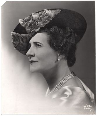 une vieille photo en noir et blanc d'une femme portant un chapeau