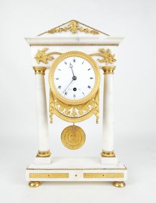 une horloge blanche et dorée posée sur un socle, sur fond blanc