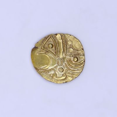 une vieille pièce d'or sur une surface blanche avec un fond blanc