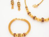an image of a gold necklace and bracelet set on a white background