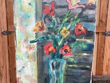 une peinture de fleurs dans un vase sur un chevalet