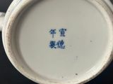 a blue and white cup with chinese writing on it