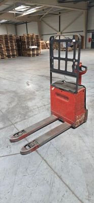 a forklift in a warehouse with pallets in the background