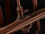 a close up of a wooden chair with a black background