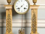 une horloge en or surmontée d'un aigle