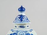 a blue and white vase with a lid sitting on a table