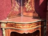 une armoire d'angle surmontée d'une étagère