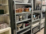 many shelves in the kitchen with pots and pans on them