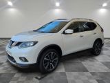 un SUV Nissan blanc garé sur un sol à damier dans un garage