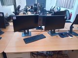 two computer monitors and a keyboard on a desk