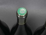 three bottles of wine are lined up on a black surface