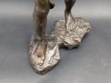 a bronze statue of a boy and a dog on a rock