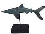 sculpture représentant un requin posée sur un socle noir