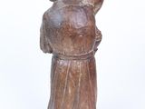 wooden figurine of a man holding a dog on a white background