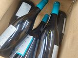 several bottles of wine are in a cardboard box on a table