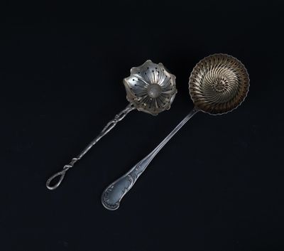 two silver spoons and a silver spoon on a black surface