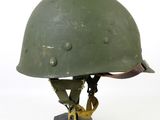 an image of a green helmet on a wooden base on a white background