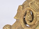 a gold clock on a white table with a white background