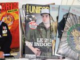 a lot of magazines on a table with a man in uniform