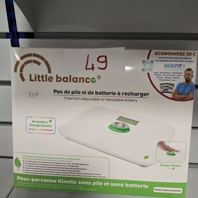 une petite balance sur l'étagère du magasin