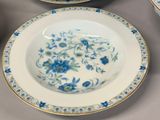 three plates with blue flowers on them sitting on a table