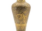 un vase doré orné d'un motif sur fond blanc