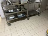 a kitchen with a stainless steel cart with plates and pans on it
