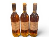 three bottles of wine sitting next to each other on a white surface