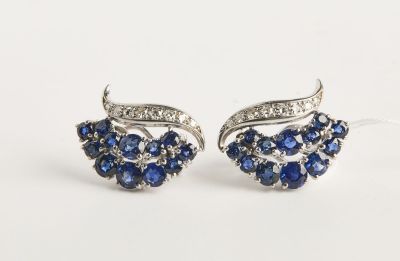 une paire de boucles d'oreilles en saphir et diamants sur fond blanc