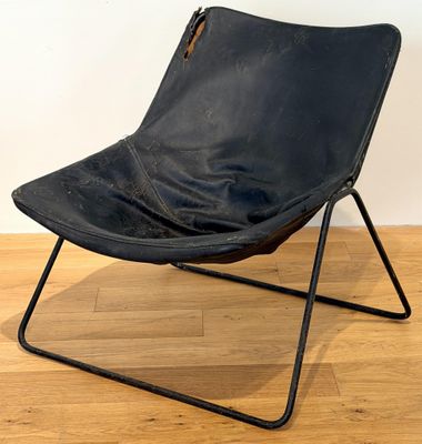black leather butterfly chair with black metal frame on wooden floor
