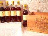 several bottles of wine in a wooden box on a table