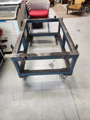 une photo d'une table en métal avec un coussin rouge