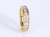 a close up of a gold and diamond ring on a white surface