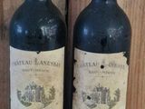 two bottles of wine sitting on a wooden shelf next to each other