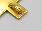 a gold cross that is on a white surface