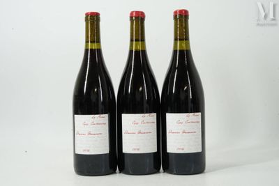 trois bouteilles de vin rouge posées l'une à côté de l'autre sur une surface blanche