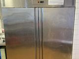a stainless steel refrigerator in a kitchen with a tile floor